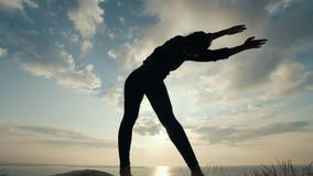 Θηλυκή σκιαγραφία που κάνει τις κλίσεις στον απότομο βράχο στην ανατολή φιλμ μικρού μήκους Θηλυκή σκιαγραφία που κάνει τις κλίσεις στον απότομο βράχο στην ανατολή φιλμ μικρού μήκους