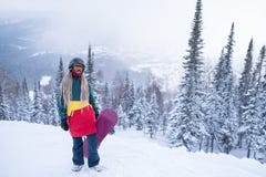 Θηλυκό snowboarder με το σνόουμπορντ στα βουνά στοκ εικόνες Θηλυκό snowboarder με το σνόουμπορντ στα βουνά στοκ εικόνες