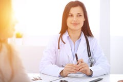 Θηλυκός γιατρός Brunette που μιλά στον ασθενή στο γραφείο νοσοκομείων Ο παθολόγος λέει για τους ιατρικούς διαγωνισμούς τα αποτελέ στοκ εικόνα Θηλυκός γιατρός Brunette που μιλά στον ασθενή στο γραφείο νοσοκομείων Ο παθολόγος λέει για τους ιατρικούς διαγωνισμούς τα αποτελέ στοκ εικόνα
