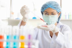 Θηλυκός επιστήμονας που ρίχνει το κόκκινο υγρό στην κούπα στοκ φωτογραφία με δικαίωμα ελεύθερης χρήσης Θηλυκός επιστήμονας που ρίχνει το κόκκινο υγρό στην κούπα στοκ φωτογραφία με δικαίωμα ελεύθερης χρήσης