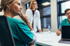 Θηλυκός ιατρικός επαγγελματίας στη συνεδρίαση του προσωπικού Στοκ Φωτογραφία Θηλυκός ιατρικός επαγγελματίας στη συνεδρίαση του προσωπικού Στοκ Φωτογραφία