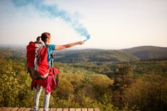 Θηλυκός ορεσίβιος που στέλνει το σήμα καπνού στην ομάδα οδοιπόρων στοκ φωτογραφία Θηλυκός ορεσίβιος που στέλνει το σήμα καπνού στην ομάδα οδοιπόρων στοκ φωτογραφία