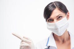 Ιατρός στη μάσκα που δείχνει το δάχτυλο μακριά Στοκ Φωτογραφία Ιατρός στη μάσκα που δείχνει το δάχτυλο μακριά Στοκ Φωτογραφία