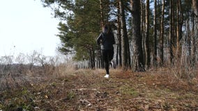 Ικανότητα workout υπαίθρια Αθλήτρια που τρέχει μέσω των ξύλων Ικανότητα workout υπαίθρια Αθλήτρια που τρέχει μέσω των ξύλων