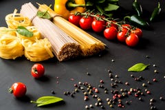 ιταλικά ζυμαρικά ακατέργ&alp Μακαρόνια και fettuccine με τις ντομάτες, τα λαχανικά, τα χορτάρια και το πιπέρι σε ένα μαύρο υπόβαθ στοκ φωτογραφίες ιταλικά ζυμαρικά ακατέργ&alp Μακαρόνια και fettuccine με τις ντομάτες, τα λαχανικά, τα χορτάρια και το πιπέρι σε ένα μαύρο υπόβαθ στοκ φωτογραφίες