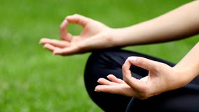 Κλείστε επάνω της νέας meditating συνεδρίασης γυναικών στο α απόθεμα βίντεο Κλείστε επάνω της νέας meditating συνεδρίασης γυναικών στο α απόθεμα βίντεο