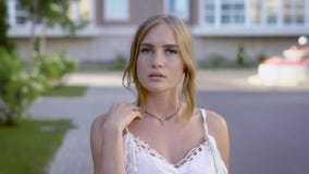 Κλείστε επάνω το πορτρέτο της νέας όμορφης ξανθής γυναίκας στο άσπρο φόρεμα δαντελλών που χαμογελά σε έναν περίπατο, κτενίζει τη απόθεμα βίντεο Κλείστε επάνω το πορτρέτο της νέας όμορφης ξανθής γυναίκας στο άσπρο φόρεμα δαντελλών που χαμογελά σε έναν περίπατο, κτενίζει τη απόθεμα βίντεο