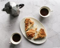 Κέικ ζύμης Filo προγευμάτων σε ένα άσπρο πιάτο geyser κατασκευαστής καφέ, φλυτζάνια καφέ σε έναν μαρμάρινο πίνακα στοκ φωτογραφία με δικαίωμα ελεύθερης χρήσης Κέικ ζύμης Filo προγευμάτων σε ένα άσπρο πιάτο geyser κατασκευαστής καφέ, φλυτζάνια καφέ σε έναν μαρμάρινο πίνακα στοκ φωτογραφία με δικαίωμα ελεύθερης χρήσης