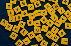 Κίτρινα κεραμίδια με τις μαύρες επιστολές στο μαύρο υπόβαθρο στοκ φωτογραφία με δικαίωμα ελεύθερης χρήσης Κίτρινα κεραμίδια με τις μαύρες επιστολές στο μαύρο υπόβαθρο στοκ φωτογραφία με δικαίωμα ελεύθερης χρήσης