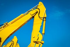 Κίτρινο backhoe με τον υδραυλικό βραχίονα εμβόλων ενάντια στο σαφή μπλε ουρανό Βαριά μηχανή για την ανασκαφή στο εργοτάξιο οικοδο στοκ φωτογραφίες Κίτρινο backhoe με τον υδραυλικό βραχίονα εμβόλων ενάντια στο σαφή μπλε ουρανό Βαριά μηχανή για την ανασκαφή στο εργοτάξιο οικοδο στοκ φωτογραφίες