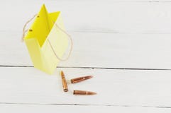 Κίτρινο πακέτο εγγράφου και τρεις σφαίρες στις παλαιές άσπρες ξύλινες σανίδες στοκ φωτογραφίες με δικαίωμα ελεύθερης χρήσης Κίτρινο πακέτο εγγράφου και τρεις σφαίρες στις παλαιές άσπρες ξύλινες σανίδες στοκ φωτογραφίες με δικαίωμα ελεύθερης χρήσης