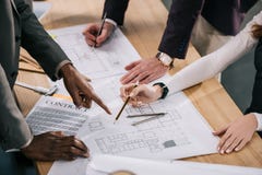 καλλιεργημένη άποψη των multiethnic αρχιτεκτόνων που συζητούν και που εργάζονται με τα σχεδιαγράμματα και τα έγγραφα στοκ φωτογραφίες με δικαίωμα ελεύθερης χρήσης καλλιεργημένη άποψη των multiethnic αρχιτεκτόνων που συζητούν και που εργάζονται με τα σχεδιαγράμματα και τα έγγραφα στοκ φωτογραφίες με δικαίωμα ελεύθερης χρήσης