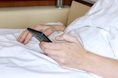Καλλιεργημένη γυναίκα που βρίσκεται στο κρεβάτι Όμορφο κορίτσι που χρησιμοποιεί το κινητό τηλέφωνο και τη στήριξη στοκ φωτογραφία Καλλιεργημένη γυναίκα που βρίσκεται στο κρεβάτι Όμορφο κορίτσι που χρησιμοποιεί το κινητό τηλέφωνο και τη στήριξη στοκ φωτογραφία