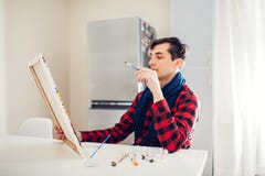 Καλλιτέχνης νεαρών άνδρων που χρωματίζει στο σπίτι τη δημιουργική ζωγραφική απεικόνιση αποθεμάτων Καλλιτέχνης νεαρών άνδρων που χρωματίζει στο σπίτι τη δημιουργική ζωγραφική απεικόνιση αποθεμάτων