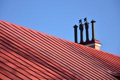 Καπνοδόχοι κινηματογραφήσεων σε πρώτο πλάνο στην κόκκινους στέγη και τον ουρανό στοκ φωτογραφία Καπνοδόχοι κινηματογραφήσεων σε πρώτο πλάνο στην κόκκινους στέγη και τον ουρανό στοκ φωτογραφία