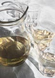 Καράφα και γυαλιά που γεμίζουν με το σπιτικό άσπρο ελληνικό κρασί, στον πίνακα σε μια ταβέρνα στο φως του ήλιου και με τις όμορφε στοκ φωτογραφίες με δικαίωμα ελεύθερης χρήσης Καράφα και γυαλιά που γεμίζουν με το σπιτικό άσπρο ελληνικό κρασί, στον πίνακα σε μια ταβέρνα στο φως του ήλιου και με τις όμορφε στοκ φωτογραφίες με δικαίωμα ελεύθερης χρήσης