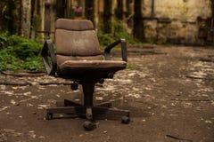 Καρέκλα βραχιόνων γραφείων στην εγκαταλειμμένη αίθουσα βιομηχανίας στοκ εικόνες Καρέκλα βραχιόνων γραφείων στην εγκαταλειμμένη αίθουσα βιομηχανίας στοκ εικόνες