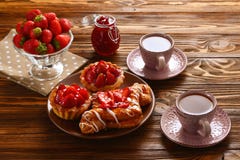 Κατανάλωση τσαγιού με τα tartlets και τα κέικ με τις φράουλες στοκ φωτογραφία Κατανάλωση τσαγιού με τα tartlets και τα κέικ με τις φράουλες στοκ φωτογραφία