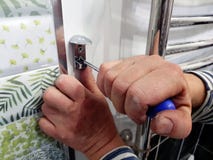 Κατασκευή και επισκευή - ένα επαγγελματικά εργαλείο και ένα κατσαβίδι στα χέρια του οικοδόμου στοκ εικόνες Κατασκευή και επισκευή - ένα επαγγελματικά εργαλείο και ένα κατσαβίδι στα χέρια του οικοδόμου στοκ εικόνες