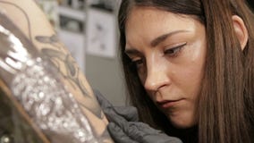 Καυκάσιος θηλυκός καλλιτέχνης δερματοστιξιών στο στάδιο της εργασίας, άποψη κινηματογραφήσεων σε πρώτο πλάνο για το πρόσωπο φιλμ μικρού μήκους Καυκάσιος θηλυκός καλλιτέχνης δερματοστιξιών στο στάδιο της εργασίας, άποψη κινηματογραφήσεων σε πρώτο πλάνο για το πρόσωπο φιλμ μικρού μήκους