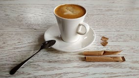 Καφές με το γάλα σε μια άσπρη κούπα σε έναν άσπρο πίνακα με τις τσάντες στοκ εικόνες Καφές με το γάλα σε μια άσπρη κούπα σε έναν άσπρο πίνακα με τις τσάντες στοκ εικόνες