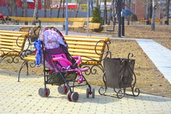 Κενή μεταφορά μωρών στο πάρκο πόλεων κοντά στον πάγκο Κοντά στο δοχείο στοκ φωτογραφία με δικαίωμα ελεύθερης χρήσης Κενή μεταφορά μωρών στο πάρκο πόλεων κοντά στον πάγκο Κοντά στο δοχείο στοκ φωτογραφία με δικαίωμα ελεύθερης χρήσης