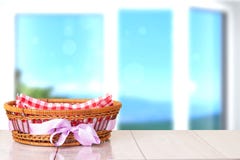 Κενό καλάθι με την πορφυρή κορδέλλα στον ξύλινο πίνακα με τη φωτεινή θαμπάδα στοκ εικόνες Κενό καλάθι με την πορφυρή κορδέλλα στον ξύλινο πίνακα με τη φωτεινή θαμπάδα στοκ εικόνες