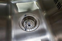 Κενός και ξηρός νεροχύτης κουζινών μετάλλων με τη σχάρα στον αγωγό στοκ φωτογραφίες Κενός και ξηρός νεροχύτης κουζινών μετάλλων με τη σχάρα στον αγωγό στοκ φωτογραφίες