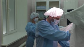 Κινηματογράφηση σε πρώτο πλάνο Ο χειρούργος γιατρών στη προστατευτική ενδυμασία, εκτελεί μια γυναικολογική λειτουργία φιλμ μικρού μήκους Κινηματογράφηση σε πρώτο πλάνο Ο χειρούργος γιατρών στη προστατευτική ενδυμασία, εκτελεί μια γυναικολογική λειτουργία φιλμ μικρού μήκους