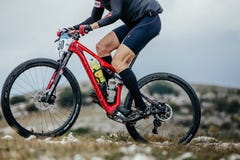 Κινηματογράφηση σε πρώτο πλάνο του αθλητή mountainbiker και του αθλητικού ποδηλάτου που συναγωνίζεται στο μπουκάλι νερό στοκ εικόνα με δικαίωμα ελεύθερης χρήσης Κινηματογράφηση σε πρώτο πλάνο του αθλητή mountainbiker και του αθλητικού ποδηλάτου που συναγωνίζεται στο μπουκάλι νερό στοκ εικόνα με δικαίωμα ελεύθερης χρήσης