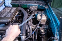 Κινηματογράφηση σε πρώτο πλάνο ενός νέου επισκευαστή αυτοκινήτων που κρατά ένα γαλλικό κλειδί στο χέρι του στοκ εικόνες με δικαίωμα ελεύθερης χρήσης Κινηματογράφηση σε πρώτο πλάνο ενός νέου επισκευαστή αυτοκινήτων που κρατά ένα γαλλικό κλειδί στο χέρι του στοκ εικόνες με δικαίωμα ελεύθερης χρήσης