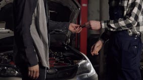 Κλείστε αυξημένος του μηχανικού και το τίναγμα πελατών παραδίδει ένα αυτόματο κατάστημα επισκευής απόθεμα βίντεο Κλείστε αυξημένος του μηχανικού και το τίναγμα πελατών παραδίδει ένα αυτόματο κατάστημα επισκευής απόθεμα βίντεο