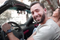 κλείστε επάνω πορτρέτο μιας συνεδρίασης ατόμων χαμόγελου πίσω από τη ρόδα ενός μετατρέψιμου αυτοκινήτου στοκ φωτογραφία κλείστε επάνω πορτρέτο μιας συνεδρίασης ατόμων χαμόγελου πίσω από τη ρόδα ενός μετατρέψιμου αυτοκινήτου στοκ φωτογραφία