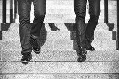 Κλείστε επάνω τα πόδια του περπατήματος δύο επιχειρηματιών κάτω από το σκαλοπάτι στη σύγχρονη πόλη στοκ φωτογραφίες με δικαίωμα ελεύθερης χρήσης Κλείστε επάνω τα πόδια του περπατήματος δύο επιχειρηματιών κάτω από το σκαλοπάτι στη σύγχρονη πόλη στοκ φωτογραφίες με δικαίωμα ελεύθερης χρήσης