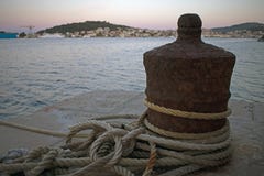 Κλείστε επάνω της σκουριασμένης πρόσδεσης βαρκών με τα σχοινιά που τυλίγονται γύρω στοκ φωτογραφία Κλείστε επάνω της σκουριασμένης πρόσδεσης βαρκών με τα σχοινιά που τυλίγονται γύρω στοκ φωτογραφία