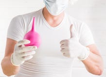 Κλείστε επάνω το πορτρέτο ενός νέου αρσενικού γιατρού με το στηθοσκόπιο που ντύνεται στο ομοιόμορφο δάχτυλο υπόδειξης στο enema κ στοκ εικόνες Κλείστε επάνω το πορτρέτο ενός νέου αρσενικού γιατρού με το στηθοσκόπιο που ντύνεται στο ομοιόμορφο δάχτυλο υπόδειξης στο enema κ στοκ εικόνες