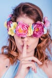 Κλείστε επάνω το πορτρέτο μιας όμορφης ξανθής νέας γυναίκας με το στεφάνι λουλουδιών στα μάτια της και ενός χεριού κοντά στα χείλ στοκ εικόνες Κλείστε επάνω το πορτρέτο μιας όμορφης ξανθής νέας γυναίκας με το στεφάνι λουλουδιών στα μάτια της και ενός χεριού κοντά στα χείλ στοκ εικόνες