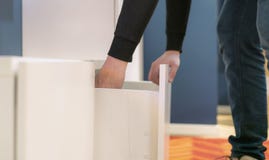 Κλείστε επάνω το χέρι ανοίγει την κρεβατοκάμαρα ραφιών στο σπίτι που ψάχνει για τα πράγματα φ στοκ εικόνα Κλείστε επάνω το χέρι ανοίγει την κρεβατοκάμαρα ραφιών στο σπίτι που ψάχνει για τα πράγματα φ στοκ εικόνα