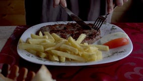 Κλείστε επάνω των χεριών γυναικών ` s κόβοντας το πιάτο κρέατος στο πιάτο στο εστιατόριο φιλμ μικρού μήκους Κλείστε επάνω των χεριών γυναικών ` s κόβοντας το πιάτο κρέατος στο πιάτο στο εστιατόριο φιλμ μικρού μήκους