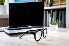 Κλειστό σημειωματάριο σε ένα lap-top, τα γυαλιά και ένα πράσινο λουλούδι στοκ φωτογραφίες με δικαίωμα ελεύθερης χρήσης Κλειστό σημειωματάριο σε ένα lap-top, τα γυαλιά και ένα πράσινο λουλούδι στοκ φωτογραφίες με δικαίωμα ελεύθερης χρήσης