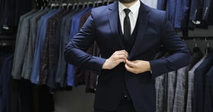 Κομψό επιχειρησιακό άτομο στο άσπρο πουκάμισο που διορθώνει το δεσμό του και που κουμπώνει το σακάκι κοστουμιών του κλείστε επάνω φιλμ μικρού μήκους Κομψό επιχειρησιακό άτομο στο άσπρο πουκάμισο που διορθώνει το δεσμό του και που κουμπώνει το σακάκι κοστουμιών του κλείστε επάνω φιλμ μικρού μήκους