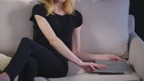 Κορίτσι με ένα lap-top στον καναπέ Μαύρη ανασκόπηση φιλμ μικρού μήκους Κορίτσι με ένα lap-top στον καναπέ Μαύρη ανασκόπηση φιλμ μικρού μήκους