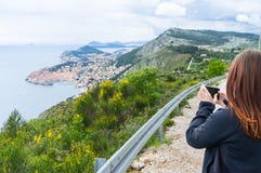 Κορίτσι που κάνει τις εικόνες από Dubrovnik στο λόφο με ένα έξυπνο τηλέφωνο σε έναν μικρό δρόμο στην παλαιά πόλη στην Κροατία στοκ φωτογραφία Κορίτσι που κάνει τις εικόνες από Dubrovnik στο λόφο με ένα έξυπνο τηλέφωνο σε έναν μικρό δρόμο στην παλαιά πόλη στην Κροατία στοκ φωτογραφία