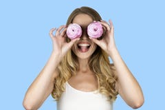 Κορίτσι που κρατά δύο cupcakes κοντά απομονωμένο στο πρόσωπο μπλε υπόβαθρό της στοκ φωτογραφία Κορίτσι που κρατά δύο cupcakes κοντά απομονωμένο στο πρόσωπο μπλε υπόβαθρό της στοκ φωτογραφία