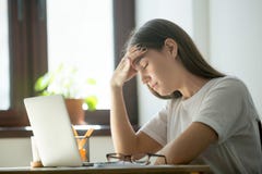 Κουρασμένο θηλυκό που βρίσκεται στον πίνακα που πάσχει από τον πονοκέφαλο στοκ εικόνα με δικαίωμα ελεύθερης χρήσης Κουρασμένο θηλυκό που βρίσκεται στον πίνακα που πάσχει από τον πονοκέφαλο στοκ εικόνα με δικαίωμα ελεύθερης χρήσης
