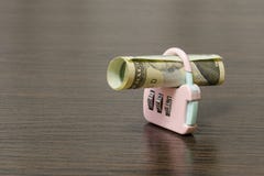 Κυλημένο επάνω τραπεζογραμμάτιο στην κλειδαριά Είναι ένα σύμβολο της αποταμίευσης οικονομίας και μετρητών στοκ εικόνα Κυλημένο επάνω τραπεζογραμμάτιο στην κλειδαριά Είναι ένα σύμβολο της αποταμίευσης οικονομίας και μετρητών στοκ εικόνα