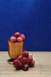 Κόκκινα σταφύλια που επιδεικνύονται σε ένα ξύλινο κύπελλο στοκ φωτογραφία με δικαίωμα ελεύθερης χρήσης Κόκκινα σταφύλια που επιδεικνύονται σε ένα ξύλινο κύπελλο στοκ φωτογραφία με δικαίωμα ελεύθερης χρήσης