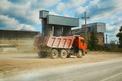 Κόκκινο μεγάλο φορτηγό στα πλαίσια των εγκαταστάσεων και ο ουρανός με τα σύννεφα στοκ φωτογραφίες με δικαίωμα ελεύθερης χρήσης Κόκκινο μεγάλο φορτηγό στα πλαίσια των εγκαταστάσεων και ο ουρανός με τα σύννεφα στοκ φωτογραφίες με δικαίωμα ελεύθερης χρήσης