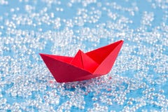 Κόκκινο σκάφος εγγράφου Origami στο μπλε νερό όπως το υπόβαθρο στοκ φωτογραφίες Κόκκινο σκάφος εγγράφου Origami στο μπλε νερό όπως το υπόβαθρο στοκ φωτογραφίες