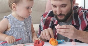 Κόρη μωρών που μαθαίνει να παίζει με το plasticine απόθεμα βίντεο Κόρη μωρών που μαθαίνει να παίζει με το plasticine απόθεμα βίντεο